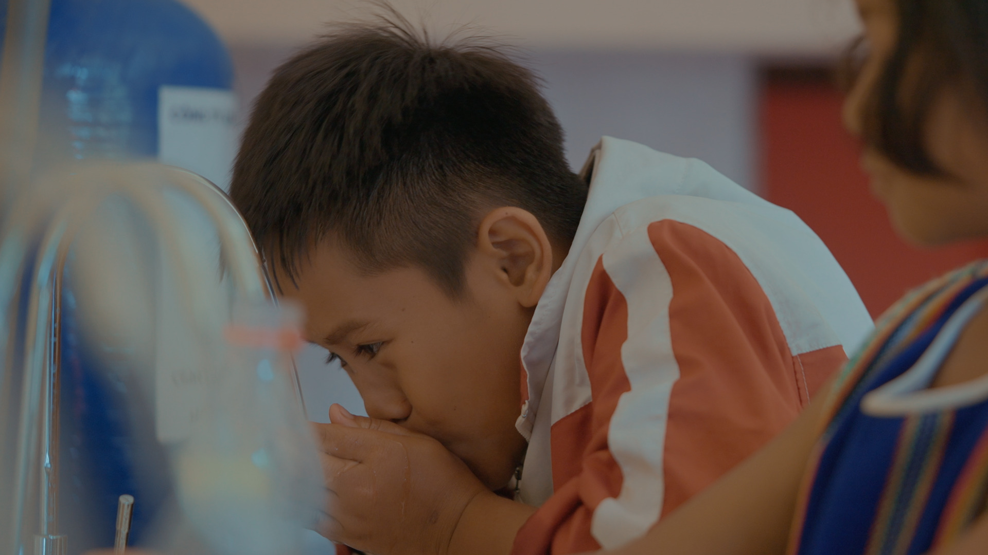 A child with his hands in his mouthDescription automatically generated